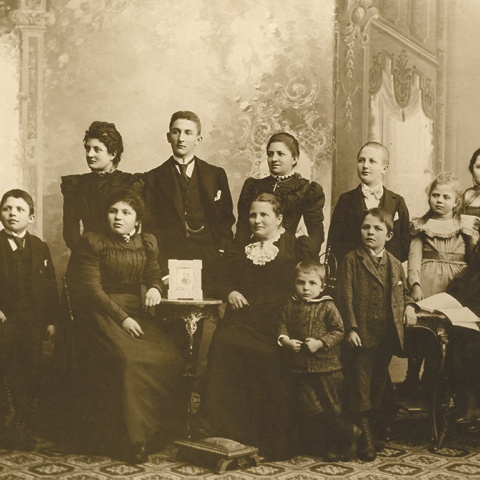 Johanna Groß mit ihren elf Kindern. Ein Porträt des wenige Jahre zuvor verstorbenen Familienvaters steht auf dem Tischchen in der Mitte. (Abbildung: Privatbesitz)