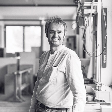 <b>Martin Bereuter</b> geboren 1973 in Lingenau, besuchte vor seinem Architekturstudium die HTL in Imst. Von 1998 bis 2006 arbeitete er bei Architekt Bruno Spagolla und studierte berufsbegleitend Architektur an der Universität Liechtenstein. Als Geschäftsführer der Tischlerei Bereuter, die er 2006 von seinem Vater übernahm, realisiert er mit seinen Mitarbeitern handwerkliche Projekte von der Konzeption bis zur Fertigstellung. Das Produktportfolio umfasst Innenausbau, individuelle Möbel, Möbelkleinserien sowie Ausstellungsinstallationen. Seit 2007 engagiert er sich als Vorstandsmitglied im Werkraum Bregenzerwald. Martin Bereuter lebt mit seiner Familie in Hard. <br>Foto: Darko Todorovic